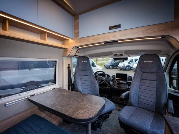 Avanti C – Innenansicht des Reisemobils mit drehbaren Vordersitzen und Tischbereich.