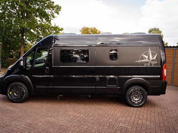 Columbus 600 D – Schwarzer Westfalia Columbus 600 D Kastenwagen von der Seite, draußen geparkt.