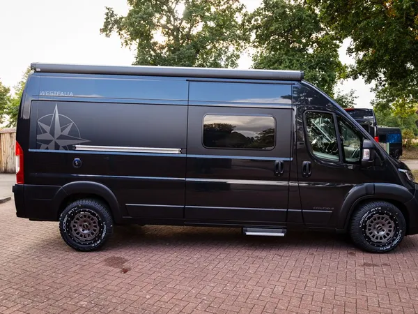 Columbus 600 D – Schwarzes Reisemobil Westfalia Columbus 600 D von der Seite, draußen geparkt.