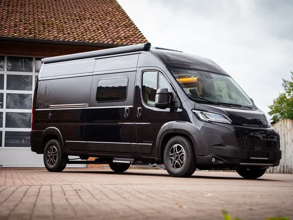 Columbus 600 D – Schwarzes Columbus 600 D Reisemobil, schräg von vorne vor Garage
