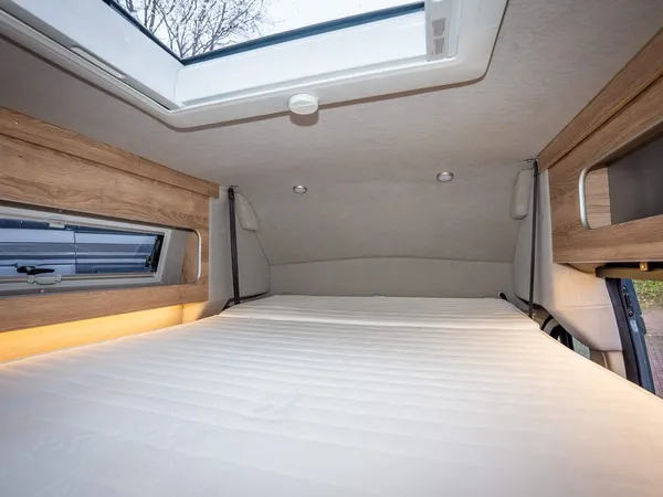 Avanti EBF – Geräumiges Hubbett im Reisemobil mit Dachluke und Seitenfenster.