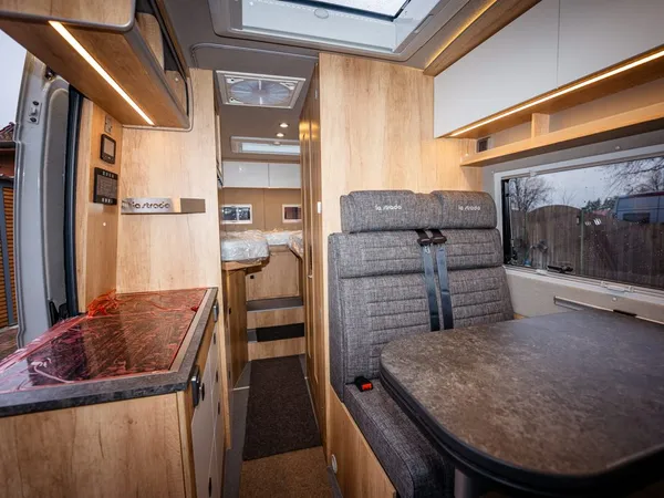 Avanti E – Blick durch den Wohnbereich eines Reisemobils mit Sitzgruppe und Küche.