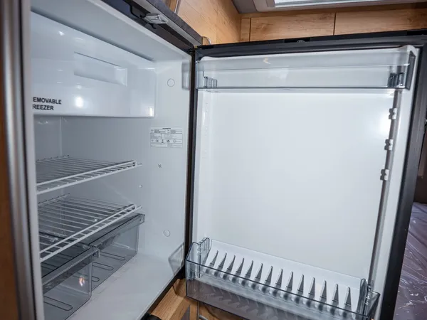 Regent S – Offener Kühlschrank im Reisemobil mit Gefrierfach und Regalen.