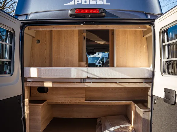Vario 545 – Heckstauraum mit offenem Bett und Holzablagen in Reisemobil