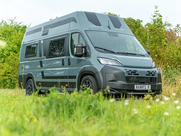 Avanti R – Graues Reisemobil Avanti R in grüner Natur, schräge Frontansicht.