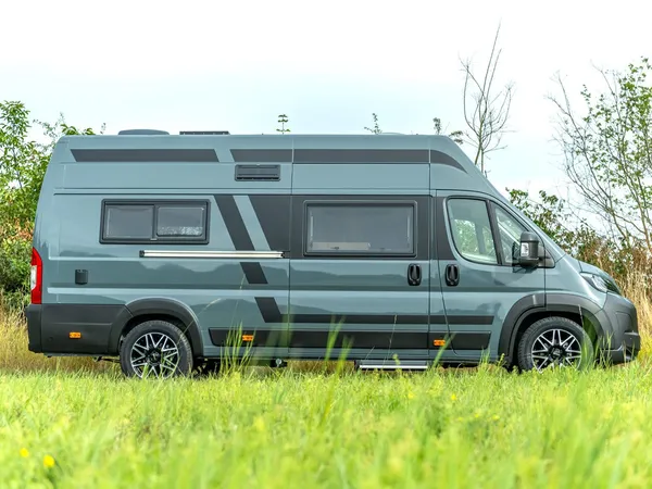 Avanti R – Graues Reisemobil Avanti R seitlich im hohen Gras stehend.