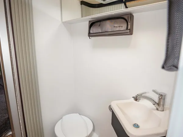 Summit 600 B – Blick ins helle Badezimmer mit Toilette und Waschbecken im Reisemobil.