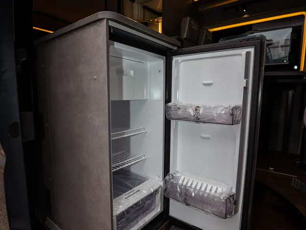 Summit Shine 600 L – Offener Kühlschrank im Reisemobil, Innenraum mit Holzboden und Beleuchtung.