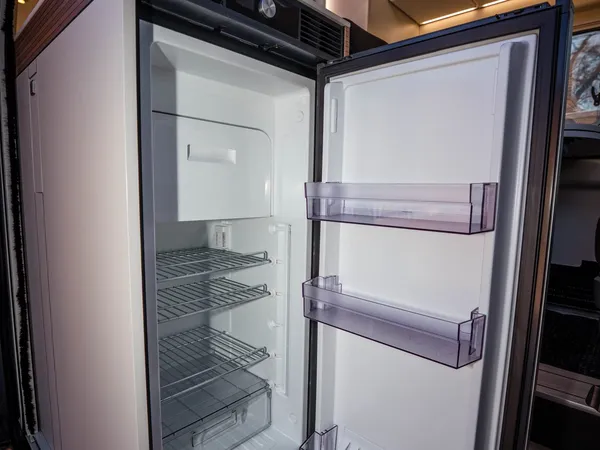 Columbus 600 E – Offener Kühlschrank im Reisemobil mit Regalen und Türfächern.