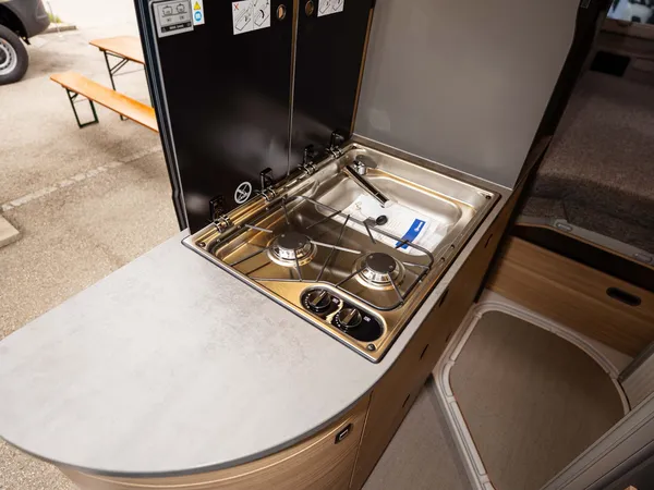 Summit Shine 640 R – Moderne Campervan-Küche mit Gaskochfeld und Spüle, Seitenblick.