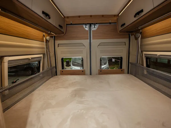 Roadcruiser Revolution – Bettbereich im Reisemobil mit Dachfenster und Oberschränken