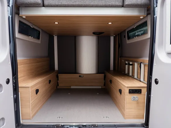 Summit Shine 640 R – Heckstauraum mit offenem Bett und Sitzbänken im Reisemobil.