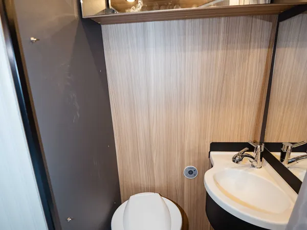 Summit Shine 640 R – Modernes Bad mit Toilette, Waschbecken und Spiegel im Reisemobil.
