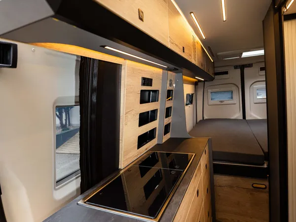 Roadstar XL Evo – Moderne Küche mit Kochfeld und Oberschränken im Reisemobil-Innenraum.