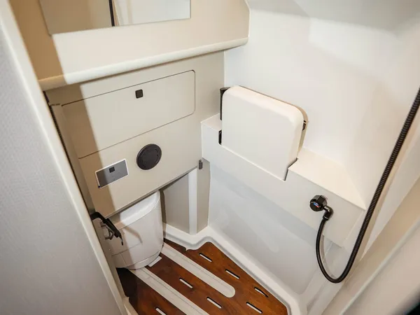 Columbus Liner – Moderne Dusche im Reisemobil mit Holzboden und Spiegel.