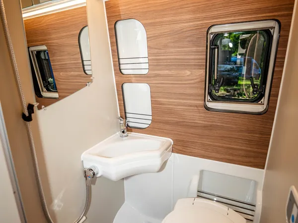 Sven Hedin 50 Jahre Edition – Modernes Bad mit WC, Waschbecken und Duschkopf im Reisemobil.