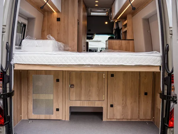 Regent EB – Heckansicht eines Reisemobils mit offener Tür, Bett und Stauraum
