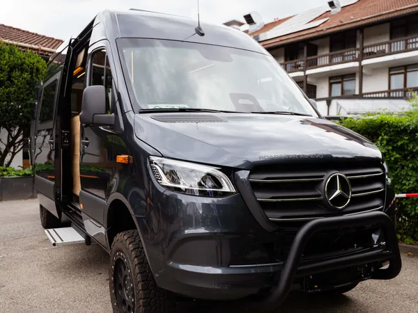 Roadstar XL Evo – Dunkelgraues Reisemobil (Roadstar XL Evo) schräg von vorne mit offener Schiebetür.