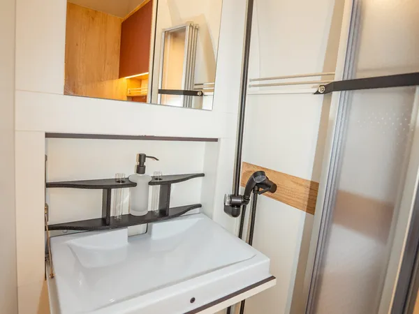 Nova M – Badezimmer im Reisemobil mit Waschbecken, Spiegelschrank und Dusche.