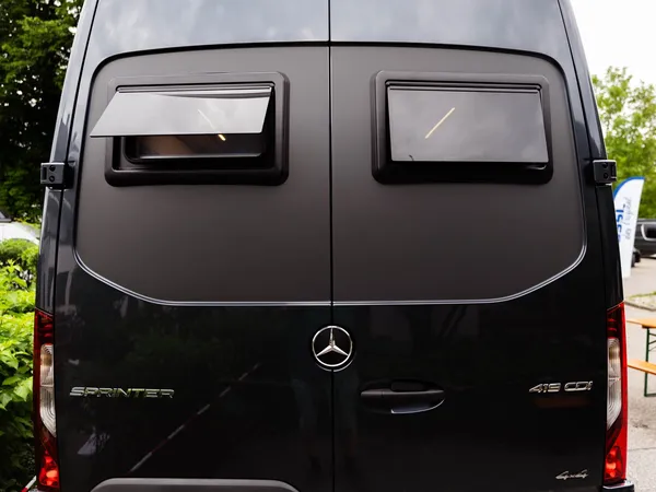 Roadstar XL Evo – Heckansicht des Roadstar XL Evo, dunkles Reisemobil mit geöffnetem Fenster.