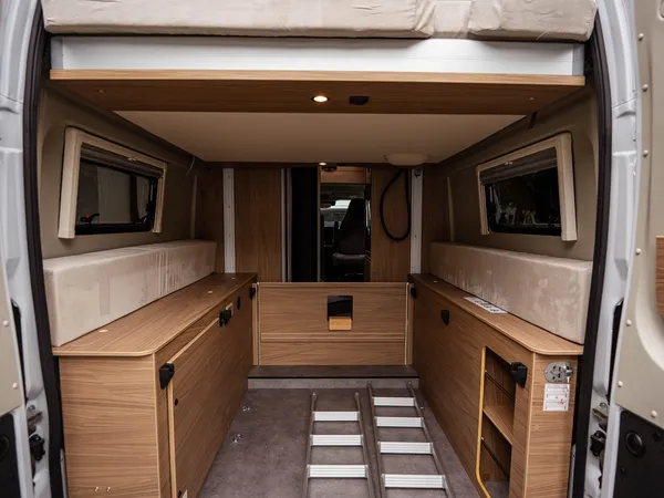 Roadcruiser Revolution – Heckstauraum mit hochgeklapptem Bett und Leiter im Reisemobil