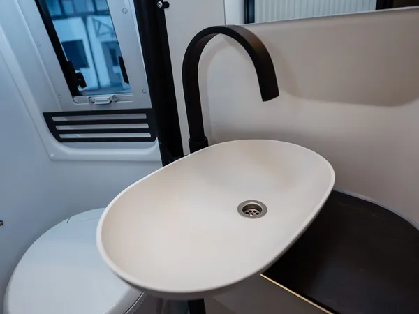 Roadstar XL Evo – Modernes Reisemobilbad mit Toilette, elegantem Waschbecken und Duschbereich.