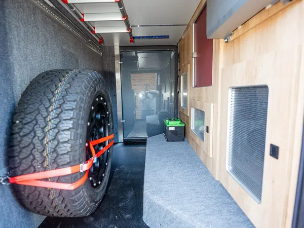 Nova M – Heckstauraum des Reisemobils mit Reserverad, Batteriekasten und Schienen.