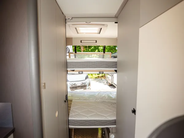 Nansen 600L – Stockbetten im Heckbereich eines Reisemobils mit Blick nach draußen.
