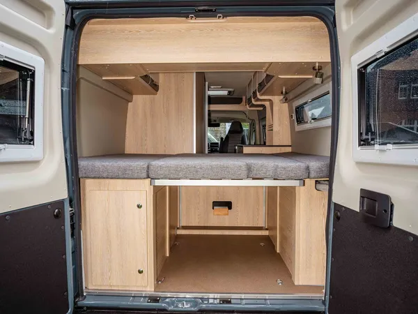 Summit 600 B – Blick in den Heckstauraum des Reisemobils mit Bett darüber