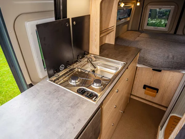 Summit 600 B – Küchenzeile mit Herd, Spüle und ausziehbarer Arbeitsfläche im Reisemobil.