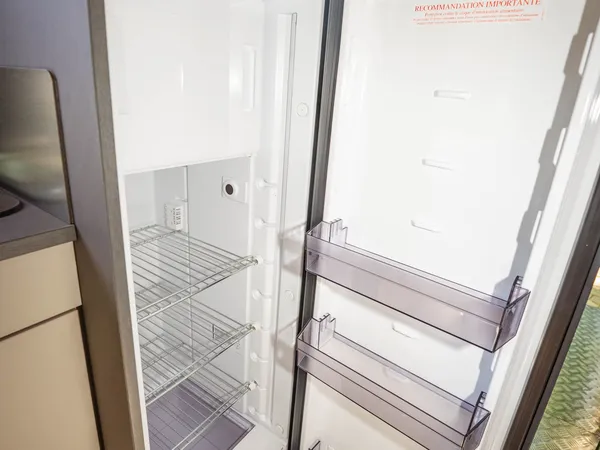 Nansen 640LS – Offener Kühlschrank im Reisemobil mit leeren Fächern.