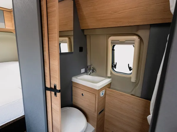 Trenta 640 – Modernes Bad mit Toilette, Waschbecken und Duschwanne im Reisemobil.