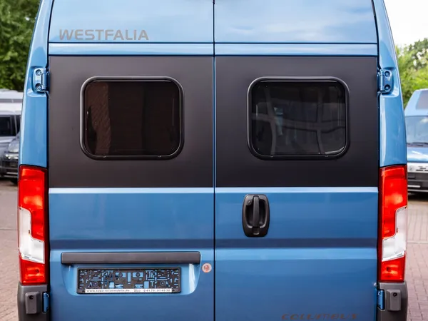 Columbus 540 D – Heckansicht des blauen Westfalia Columbus 540 D Reisemobils mit Aufstelldach.