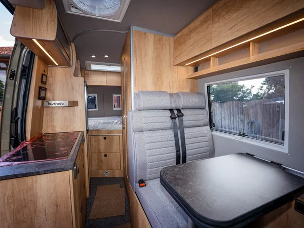 Regent S – Blick durch das Reisemobil mit Sitzgruppe, Küche und Bettbereich