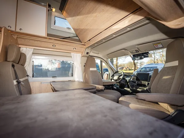 Vario 545 – Innenraum eines Reisemobils mit Cockpit, Sitzen und Tisch.