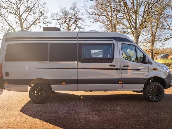 Regent EB – Graues Reisemobil (Regent EB) von der Seite auf gepflastertem Untergrund.