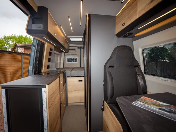 Roadstar XT – Blick durch den Wohnbereich eines Reisemobils mit Küche, Bett und Sitzgruppe.