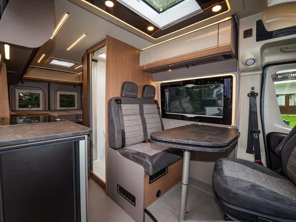 Summit Prime 640 – Heller Innenraum eines Reisemobils mit Küche, Sitzgruppe und Bad.