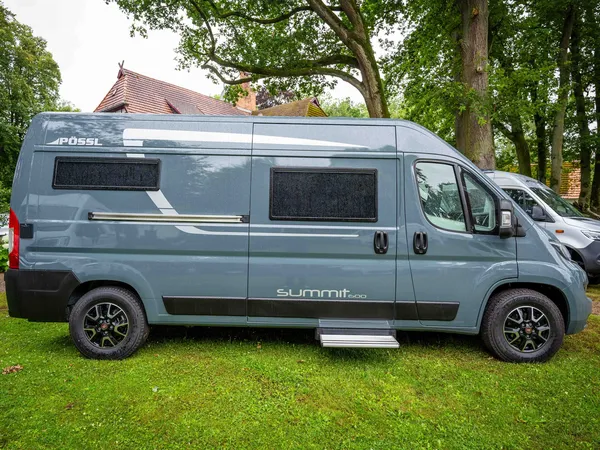 Summit 600 B – Grauer Pössl Summit 600 B Campervan von der Seite auf Rasen.
