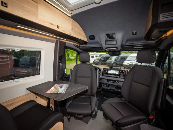 Roadstar XT – Innenansicht mit drehbaren Vordersitzen, Tisch und seitlichem Fenster.