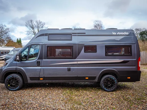 Avanti F – Graues La Strada Reisemobil von der Seite auf Schotterparkplatz.