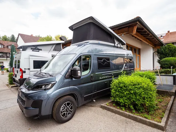 Summit Shine 600 L – Graues Reisemobil mit offenem Aufstelldach, schräg von vorne.