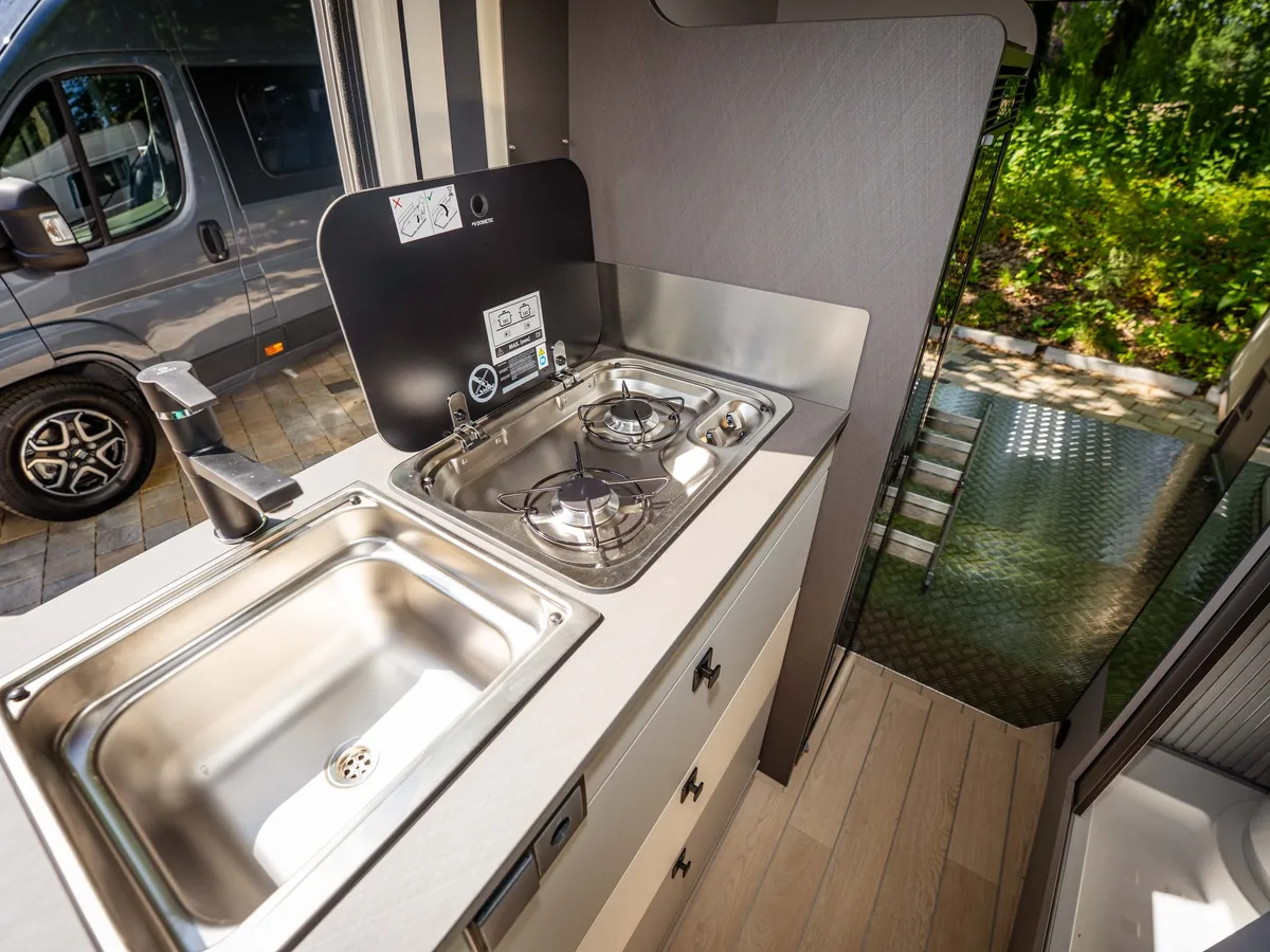 Nansen 640LS – Moderne Küchenzeile mit Spüle und Gasherd im Reisemobil.