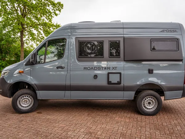 Roadstar XT – Grauer Pössl Roadstar XT Campervan, Seitenansicht, auf gepflastertem Untergrund.