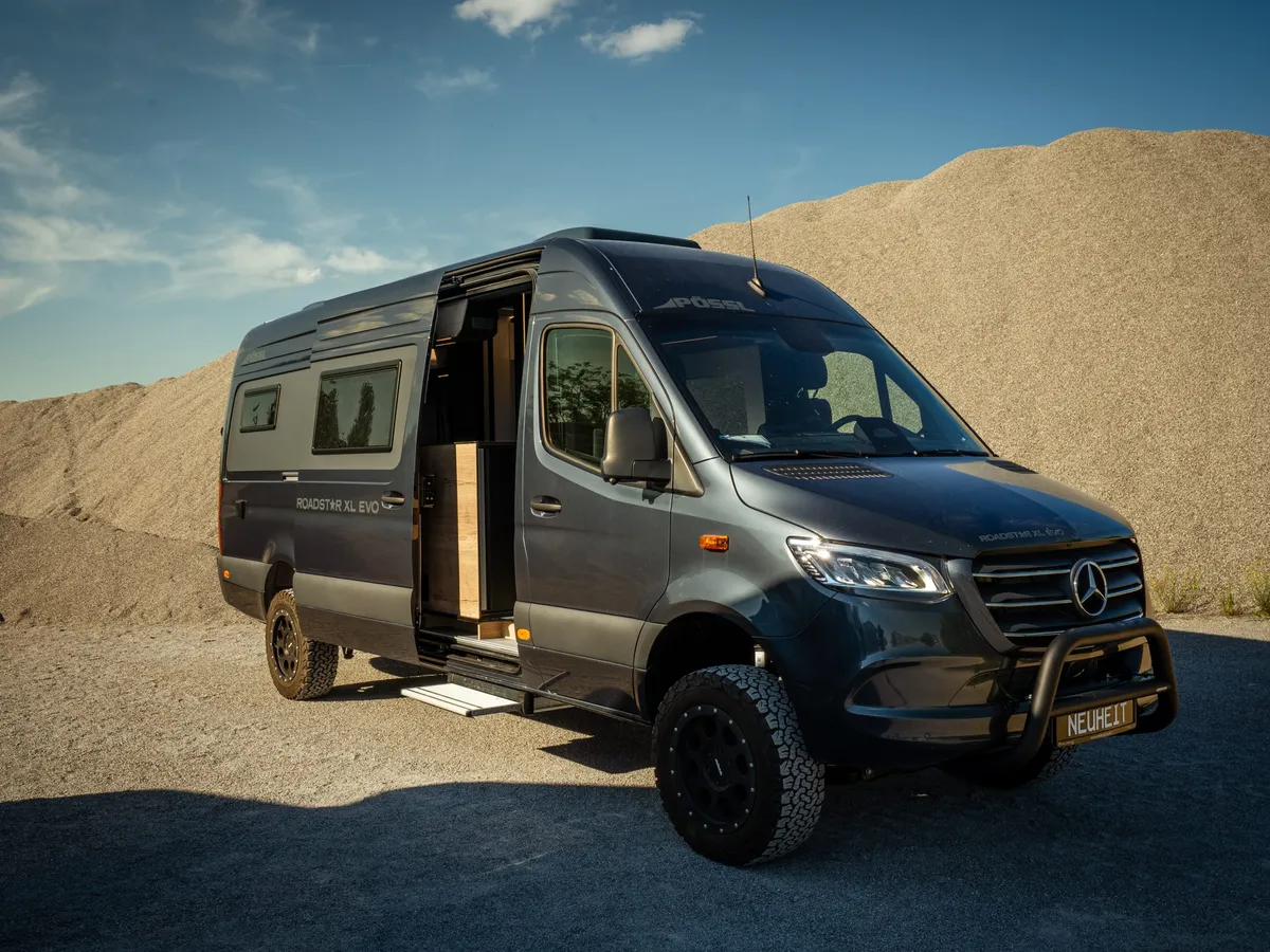 Roadstar XL Evo – Dunkelgraues Reisemobil (Roadstar XL Evo) schräg von vorne auf Schotter.