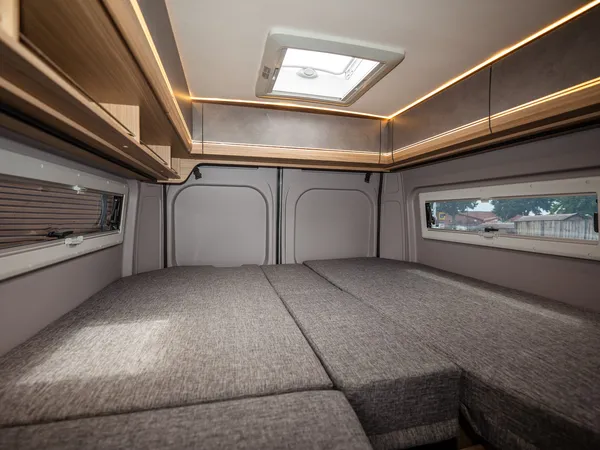 Summit Shine 600 L Elegance – Gemütliches Bett im Reisemobil mit Dachluke und Stauschränken.