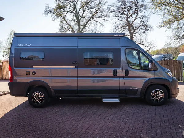 Columbus 600 E – Westfalia Columbus 600 E Reisemobil, Seitenansicht, grau, auf gepflastertem Hof.