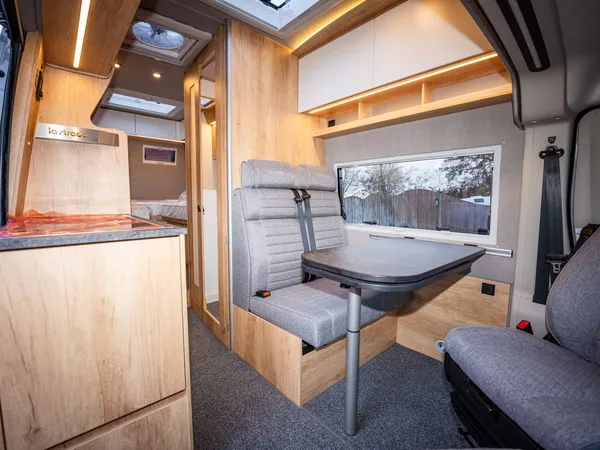Avanti EB – Innenansicht mit Sitzgruppe, Tisch und Blick zur Küche und Bettbereich.