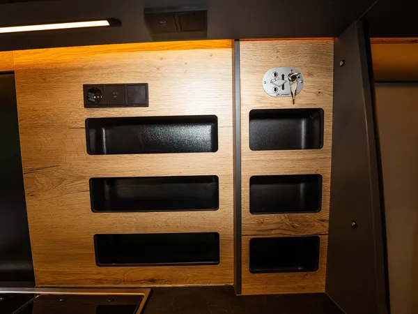 Roadstar XL Evo – Detailaufnahme eines Holzpaneels mit Fächern, Steckdose und Schlüsselschalter im Innenraum.