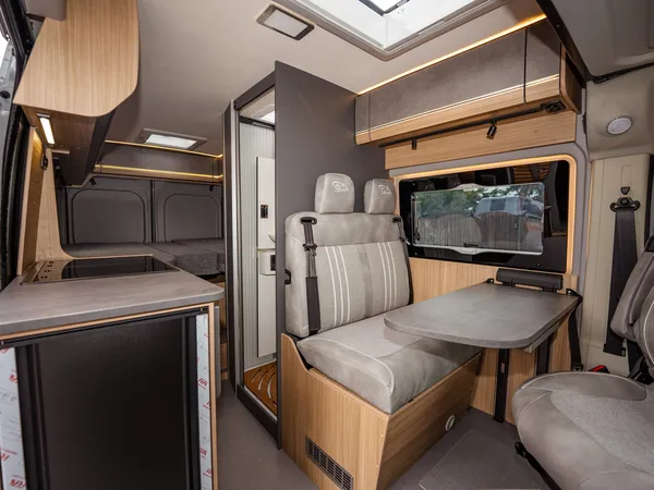 Summit Shine 600 L Elegance – Innenansicht des Campers mit Küche, Sitzgruppe und Blick zum Bett